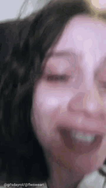 a close up of a woman 's face with her eyes closed and mouth open .