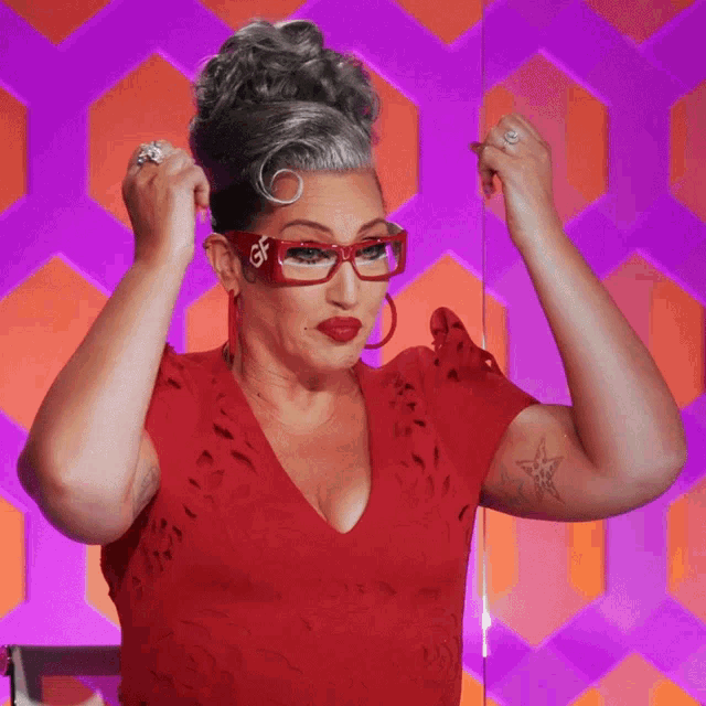 a woman wearing a red dress and glasses with the letter x on them