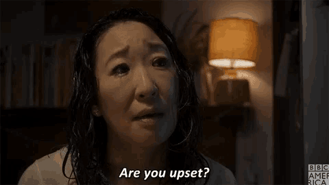 a woman is sitting in front of a lamp and asking are you upset ?
