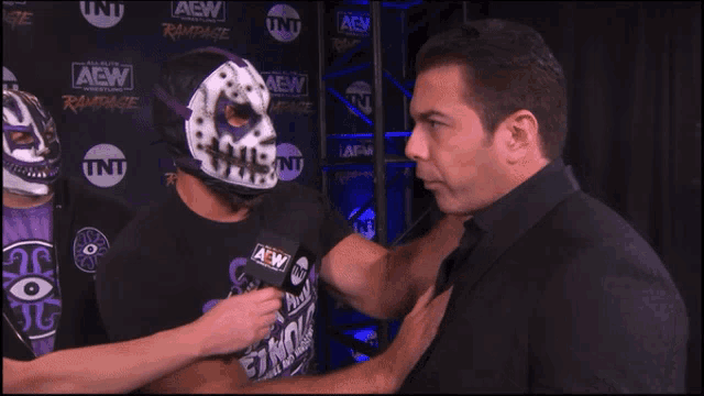 a man in a black shirt with aew on it