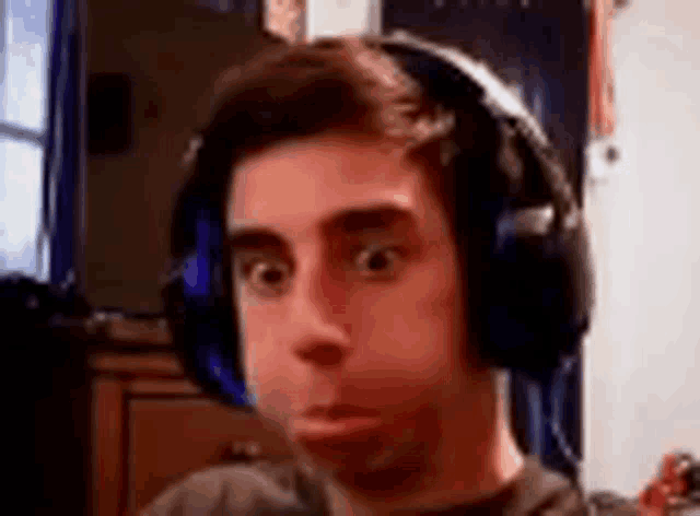 a man wearing headphones making a funny face .