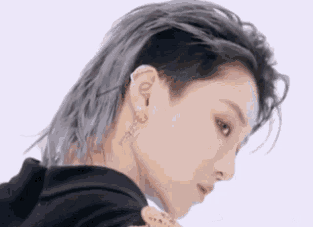 a close up of a person 's face with a shaved head and earrings .