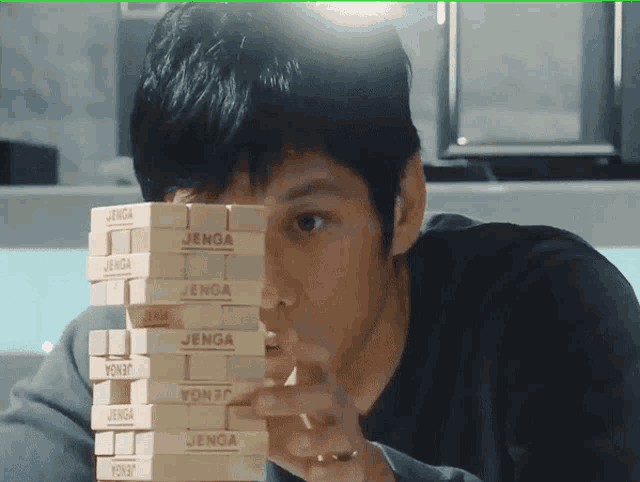 a man playing jenga with a stack of blocks