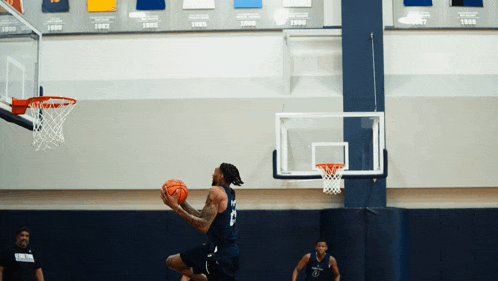 a basketball player with the number 15 on his jersey is jumping to dunk the ball