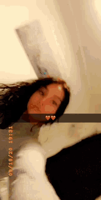 a girl is taking a selfie in a bathroom with a heart on her forehead .