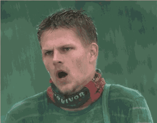 a man wearing a survivor scarf around his neck yawning