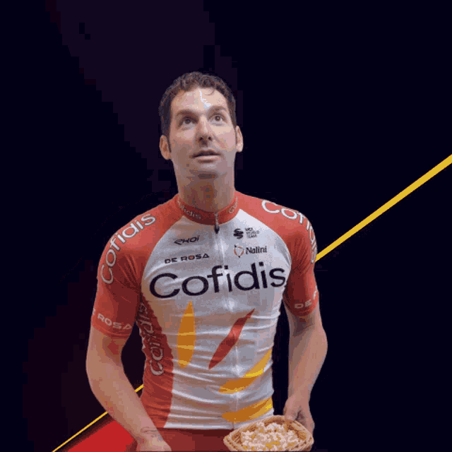 a man wearing a red and white cofidis jersey giving a thumbs up