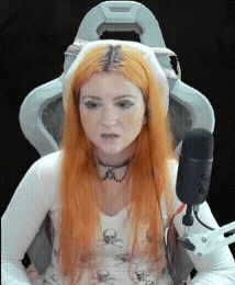 a woman with red hair is sitting in a chair with a microphone in front of her .
