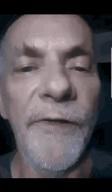 a close up of a man 's face with a beard making a funny face