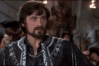a man with a beard is wearing a black and white jacket with stars on the sleeves .