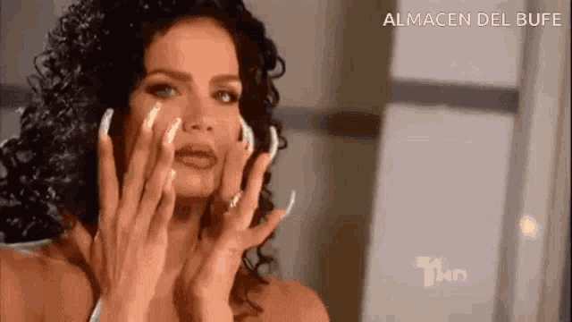 a woman with long nails is looking at herself in the mirror