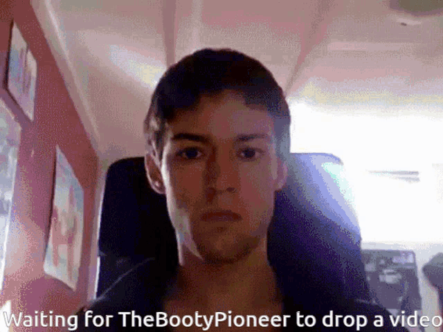 a man sitting in a chair with the words waiting for the bootypioneer to drop a video below him