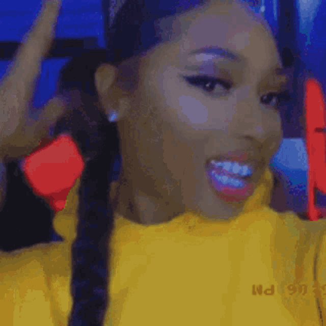 a woman is wearing a yellow sweater and smiling .