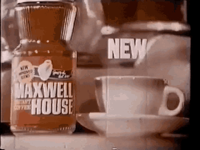 a bottle of maxwell house instant coffee is sitting next to a cup of coffee on a saucer .