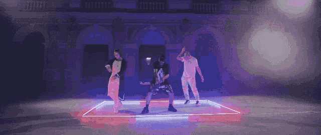 a group of people are dancing in front of a building with purple lights