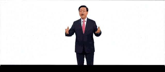 a man in a suit and tie stands in front of a wall that says " more "