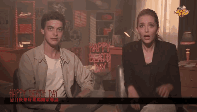 a man and woman sitting in front of a sign that says happy death day