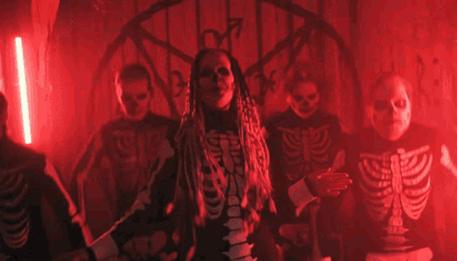 a group of people dressed as skeletons are standing in a dark room