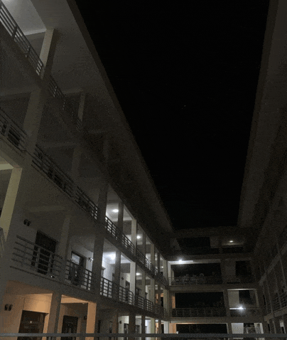 a building with a lot of balconies and stairs is lit up at night