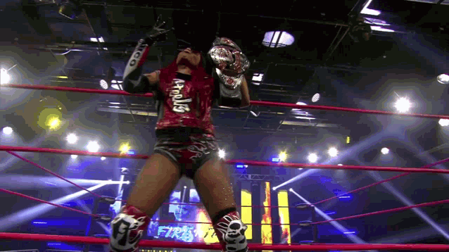 a wrestler in a red shirt with the word apollos on it