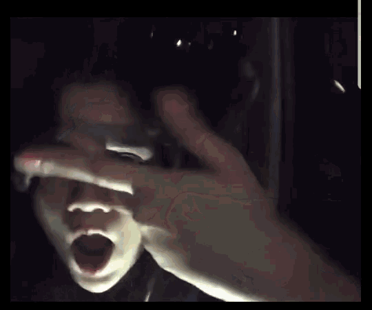 a close up of a person 's face in the dark with their mouth open