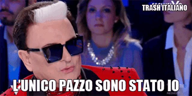 a man wearing sunglasses and a red suit says l' unico pazo sono stato 10
