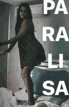 a woman in a dress is standing on a bed .