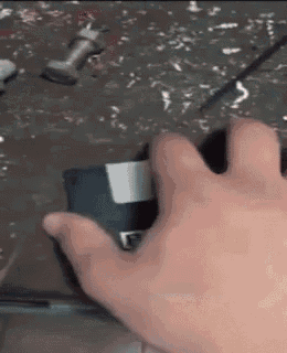 a close up of a person 's hand holding a floppy disc .