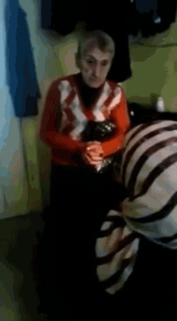 a woman in a red and white sweater is standing next to another woman in a striped shirt