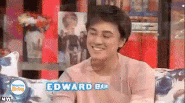 a young man is sitting on a couch with the name edward bar written on it