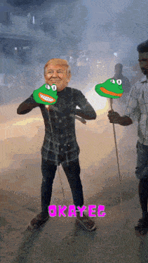 a man is holding a stick with a frog face on it and the word okayer is on the bottom of the picture