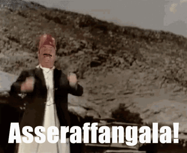 a man with a mustache and a red hat is standing in front of a mountain and the words asseraffaangala