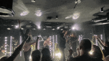 a group of people standing on a stage with a sign that says " the mountain "