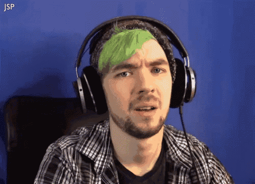 a man with green hair is wearing headphones and the letters jsp are visible in the corner