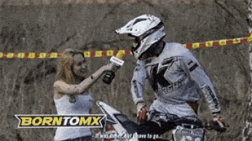 a man on a dirt bike is being interviewed by a woman with borntomx written in the corner