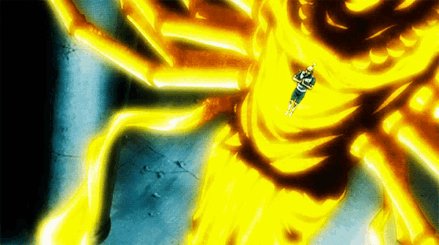 a man in a blue shirt is standing in front of a giant yellow flame