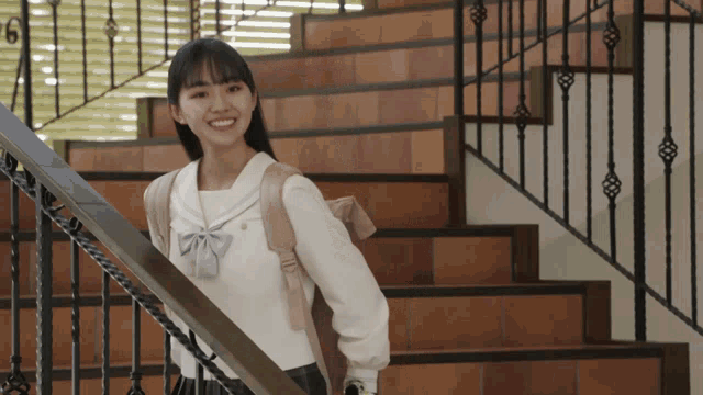 a girl standing on a set of stairs with the number 6 in the background
