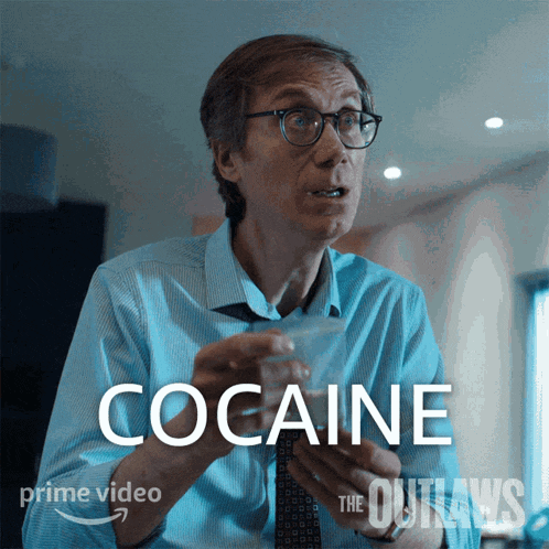 a man in a blue shirt and tie is holding a bottle of cocaine