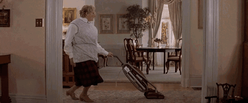 a woman is vacuuming the floor in a living room
