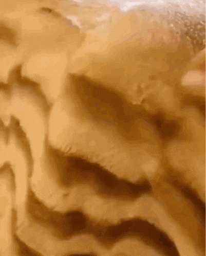 a close up of a sandy surface with waves