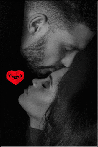 a man kissing a woman with a red heart in the background
