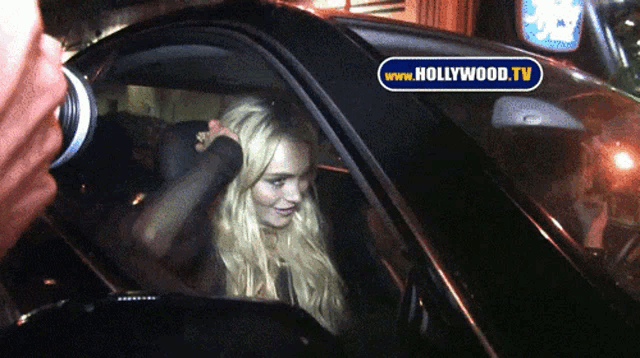 a woman in a car is being photographed by a hollywood tv camera