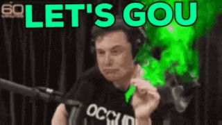 elon musk is wearing headphones and holding a green object in front of a microphone and says let 's go .