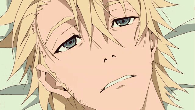 a man with blonde hair and blue eyes is laying on a bed