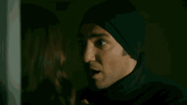 a man and a woman are looking into each other 's eyes in a dark room