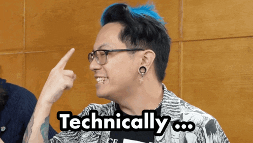 a man with blue hair and glasses says technically with his finger up
