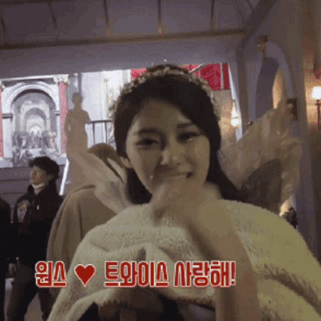a woman with a crown on her head is covered in a white blanket and says i love you in chinese