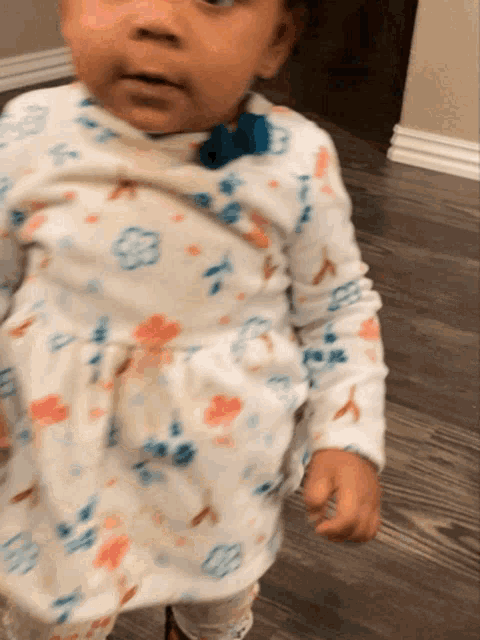 a baby wearing a bow tie and a louis vuitton outfit
