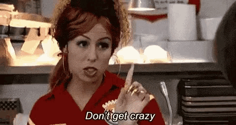 a woman in a red uniform is giving a middle finger in a restaurant .
