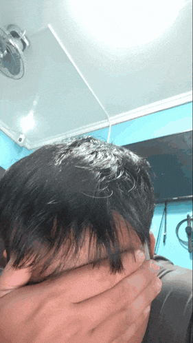 a person covering their face with their hand in a room